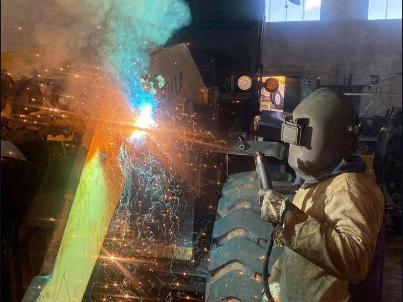 Soldador da Hidro Minas executando solda em componente de equipamento pesado